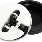 A pair of black and white earphones neatly coiled in a circular white and black case, with the lid partially open, revealing the earphones inside.