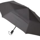 A black, compact umbrella with a curved handle and eight panels is open, showcasing its streamlined design.