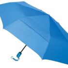 A bright blue umbrella with a closed handle and a small wrist strap is partially open, displaying its canopy against a plain white background.