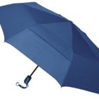 A blue collapsible umbrella is fully open, revealing its fabric panels. It has a black shaft and a handle with a small wrist strap.