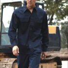 A person wearing a white hard hat and navy blue workwear stands in front of a construction vehicle. Trees are visible in the background. The words BOQIN and WORK WEAR appear on the image.