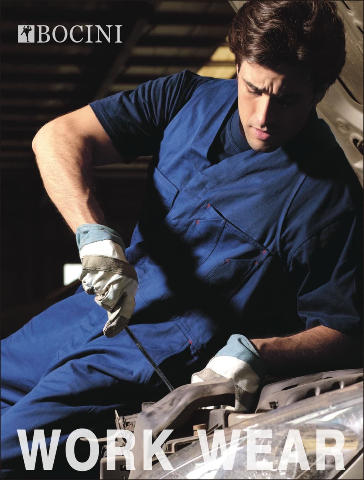 A person wearing a blue work uniform and gloves is focused on repairing a vehicle engine. The word BOCINI is at the top, and WORK WEAR is at the bottom of the image.