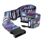 A colorful belt with a plastic buckle, featuring a vibrant floral and paisley pattern on a dark background. The design includes various colors such as red, blue, green, and yellow.