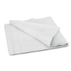 A folded white microfiber cloth with visible layers and soft texture, resting on a plain, neutral background.