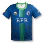 Blue and green rugby jersey with BFB in white on the front. The jersey features a stylized blue lion logo and a RUGBY emblem. Additional patterns and sponsor logos decorate the design.