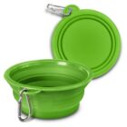 A green collapsible pet bowl with a carabiner is shown open in the foreground, displaying its expandable design. Another bowl, collapsed flat, is in the background. Both bowls are designed for portability and convenience.