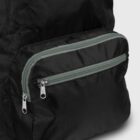 Close-up of a black fabric bag with a front pocket and two parallel, silver zipper closures featuring green edges. The texture appears smooth and slightly shiny, indicating a lightweight material.