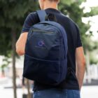 Person carrying a navy backpack with PARTICLE logo on a city street.