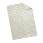 A sheet of transparent wrapping paper with a gold geometric triangle pattern repeating throughout. The paper is slightly rolled at the top right corner, revealing its semi-transparent quality.