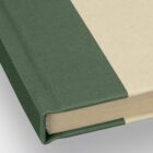 A hardcover book with a green spine and beige cover, shown from the corner angle.
