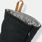 Black fabric pouch with striped lining and a brown loop handle at the top.