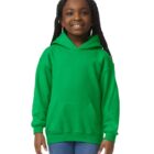 Smiling girl wearing a bright green hoodie and blue jeans against a white background.