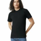 A person with long curly hair wears a plain black t-shirt and blue jeans, standing with hands in pockets against a white background.