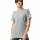 A person with short brown hair is wearing a plain gray T-shirt and dark pants. They are standing against a white background.