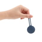 Hand holding a small round blue silicone item with a loop.