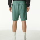 Person wearing green shorts, white socks, and white shoes, shown from the back.