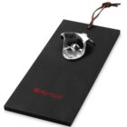 Black wooden bottle opener with metal opener and leather hanging strap.