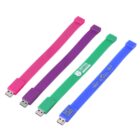 Four colorful USB flash drives in pink, green, purple, and blue, designed as wristbands.