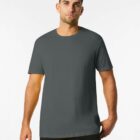 A man with short brown hair and stubble wearing a dark green t-shirt stands against a plain white background, looking directly at the camera. The t-shirt is simple with no visible logos or designs.