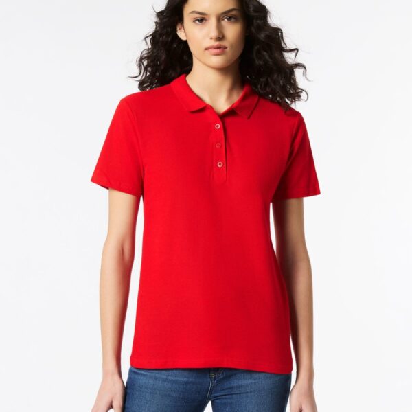 Person in a red polo shirt and blue jeans standing against a plain white background.
