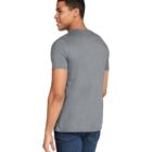 A person with short hair is wearing a plain gray t-shirt and blue jeans, standing and looking slightly to the side against a white background.
