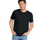 A man in a black T-shirt and blue jeans stands against a plain white background, smiling with one hand in his pocket.