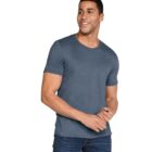 A man wearing a blue T-shirt and jeans smiles while looking off to the side. He is holding his hands together in a relaxed pose against a white background.