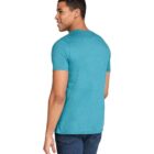 A person standing and looking to the side, wearing a teal T-shirt and dark jeans. The background is plain white.