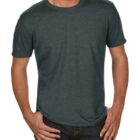 A person wearing a dark gray T-shirt and dark jeans stands with hands in pockets against a plain background.