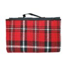 Red and black plaid picnic blanket folded with a handle on top.