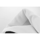 Close-up of a textured, white fabric with a waffle pattern against a plain white background.