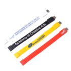 Four flexible USB wristbands in white, black, yellow, and red with various branding.