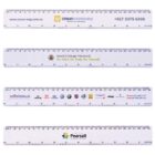Four white plastic rulers, each featuring different printed logos and contact details for Crown Engineering, Marist College Penshurst, MacCarrolls dealership, and Pearsall Primary School. Each ruler measures up to 31 centimeters or 12 inches.