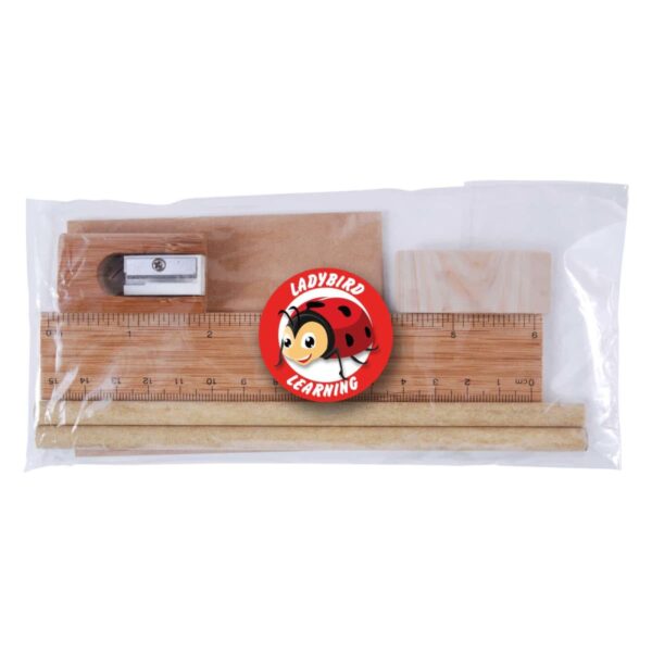 A clear plastic bag contains a wooden ruler, two wooden pencils, an eraser, and a sharpener. In the center is a round red emblem with a cartoon ladybird and the text Ladybird Learning.