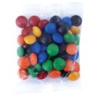 A clear bag filled with colorful candy-coated chocolate pieces.