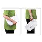Person in a green shirt holding a white bag with text. The bag is shown from the front and side, highlighting its design and features.