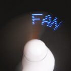 Spinning fan with LED lights displaying the word FAN in blue on a dark background.