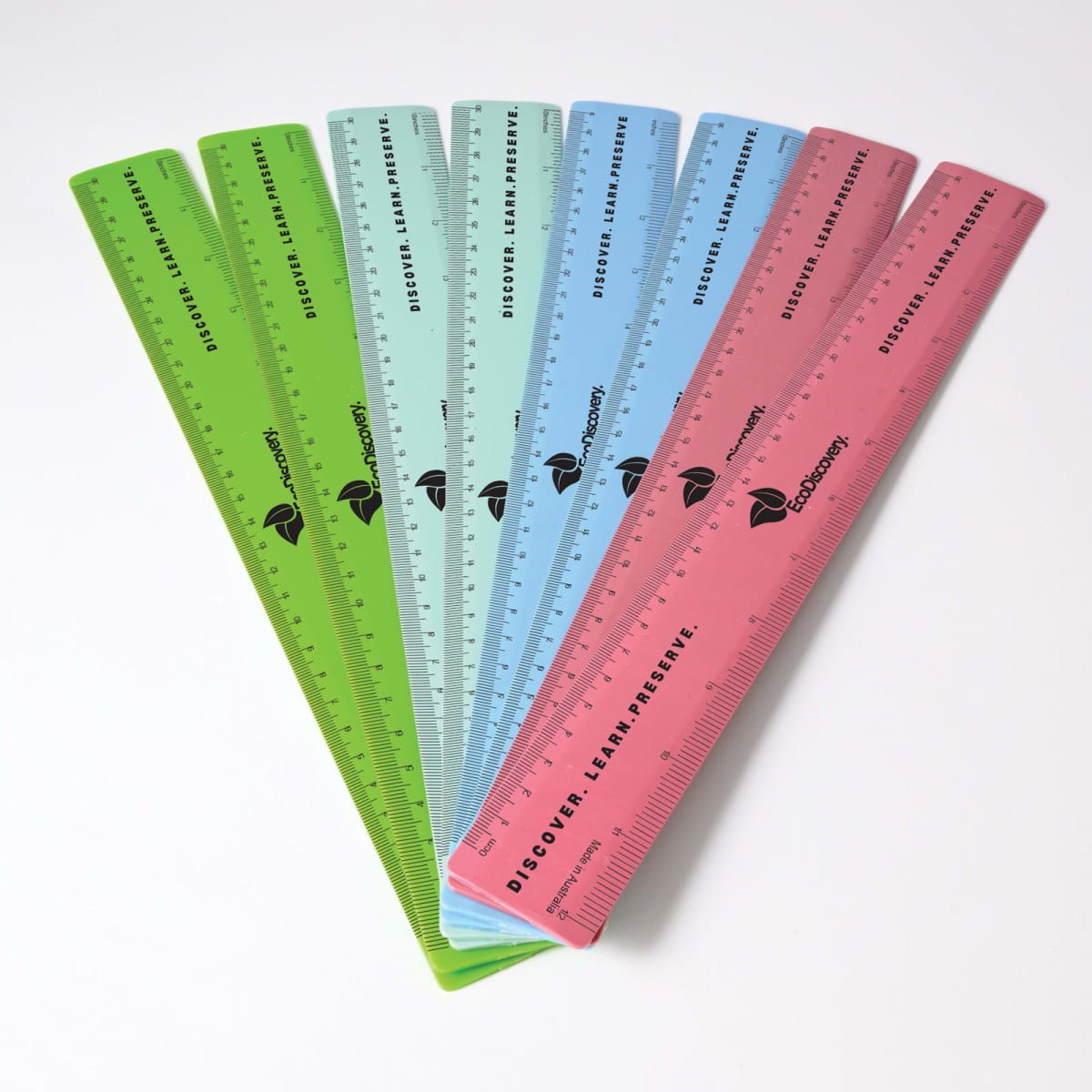 A set of six translucent plastic rulers in green, blue, and red, fanned out on a white surface. Each ruler has measurement markings and the text Discover. Learn. Preserve. along with a logo in black.