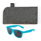 A pair of blue sunglasses with dark lenses is placed in front of a gray felt case. A small black tag on the case reads made from recycled plastic bottles. The image has a simple white background.