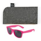 Pink sunglasses with dark lenses are placed in front of a gray felt case. The case has a black tag that mentions it is made from recycled plastic bottles.