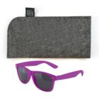 Purple sunglasses with black lenses are placed in front of a gray felt case made from recycled plastic bottles. The case has a black tag with text describing the recycled material.