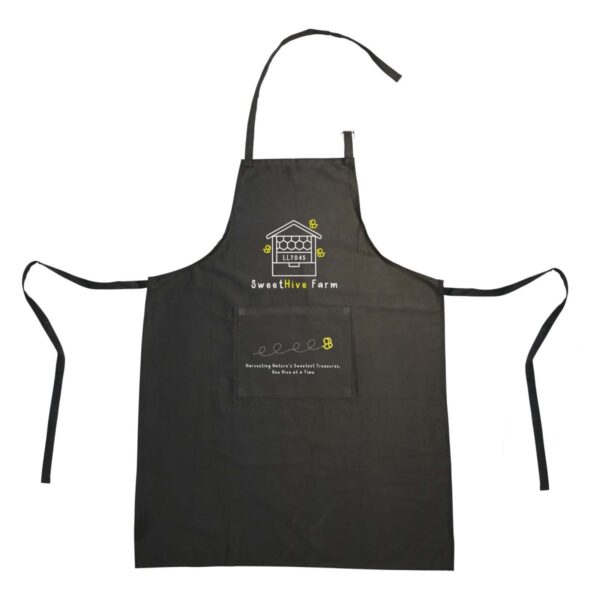 A black apron with the Sweet Hive Farm logo, featuring a house and bee design. It has neck and waist ties, a large front pocket, and decorative yellow bee and honeycomb illustrations.