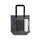 Gray tote with notebook, pen, candies, and white thermos arranged neatly on it.