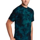 Man wearing a dark tie-dye t-shirt and jeans standing against a white background.