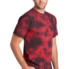 Man in red and black tie-dye shirt and jeans, standing against a white background.