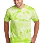 Man in a bright green tie-dye shirt smiling, stands with hands in pockets.