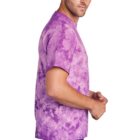 Man in a purple tie-dye T-shirt and jeans, standing sideways.