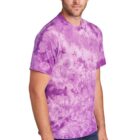Man wearing a purple tie-dye t-shirt and jeans against a white background.