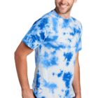 Man in a blue tie-dye shirt smiles while looking to the side.