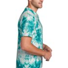 Man in a turquoise tie-dye shirt and jeans, standing in profile.